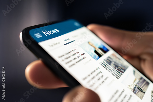 News online. Phone with newspaper headlines and feed. Digital press article. Reader watching latest titles. Mockup media publication website in smartphone. Man reading text on mobile screen. photo
