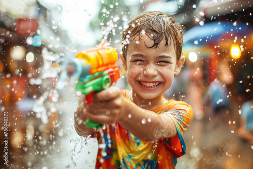 Happy traveler european boy wearing summer shirt holding colourful squirt water gun over blur city, Water festival holiday concept © grapestock
