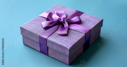 A purple box with a purple bow on top of it