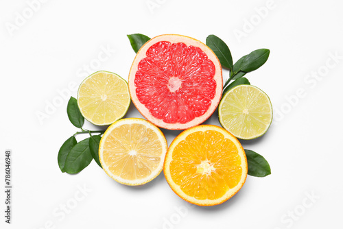 Different cut citrus fruits and leaves on white table, flat lay