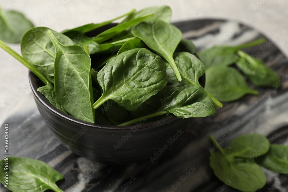 Fresh spinach leaves in bowl on table, closeup Fresh spinach leaves in bowl on table, closeup