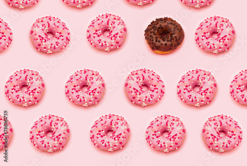 Pattern of pink doughnuts and a single chocolate doughnut