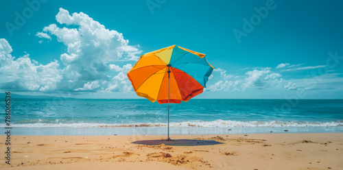 A colorful umbrella is sitting on the beach  providing shade from the sun