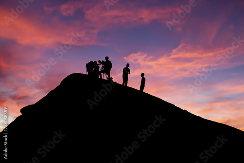 Silhouetted team conducting volcano research during picturesque sunset backdrop photo