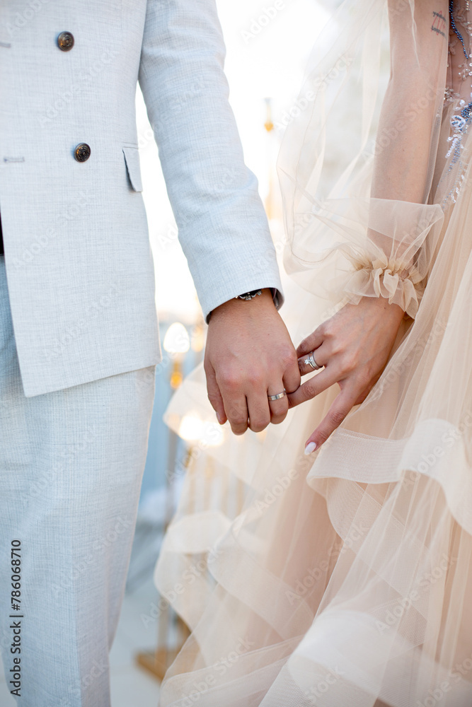 Close-up photo of the men`s holding woman hand with golden wedding ring with diamond. Wedding ring before the proposal. Luxury wedding rings Close-up photo of the men`s holding woman hand with golden wedding ring with diamond. Wedding ring before the proposal. Luxury wedding rings