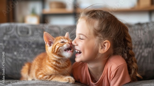 With contagious laughter  the jovial girl revels in the playful affection of her cat  sharing a heartwarming moment of pure joy and friendship on the couch. 