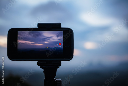 Smartphone time-lapse capturing sunrise on the tripod.
