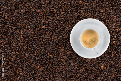 Top view background of aromatic brown coffee beans and cup of espresso.