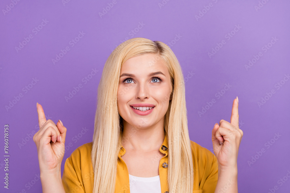 Photo portrait woman pointing finger up recommending empty space isolated pastel purple color background Photo portrait woman pointing finger up recommending empty space isolated pastel purple color background