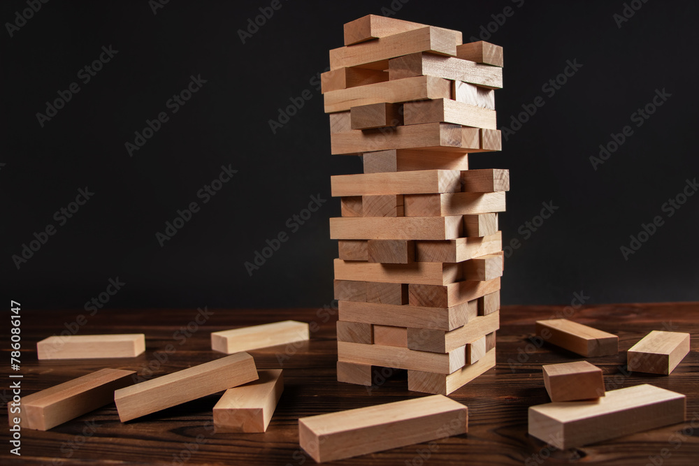 tower made of wooden blocks on dark background tower made of wooden blocks on dark background
