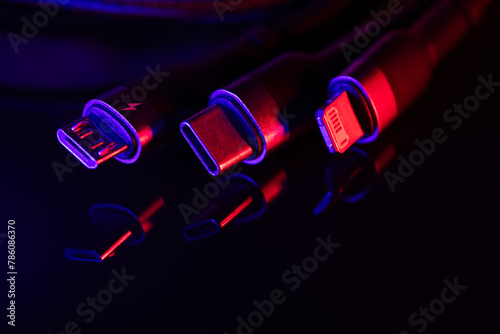 Different USB charging plugs on dark background. USB Type C, Micro USB, Usb lightning