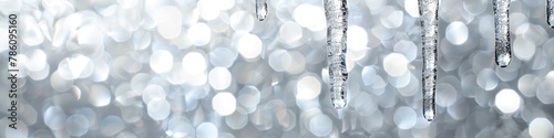 A shimmering icicle ornament dangling elegantly against a frosty silver background. 