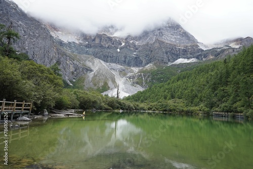 Lake and cloud-capped mountains in the Daocheng Yading National Park, Sichuan, China.