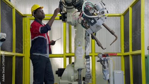 Group of multiethnic engineer researching and developing a robotics arm in scientific technology laboratory. Technician examining Industrial robot machine. Automated and manufacturing factory concepts