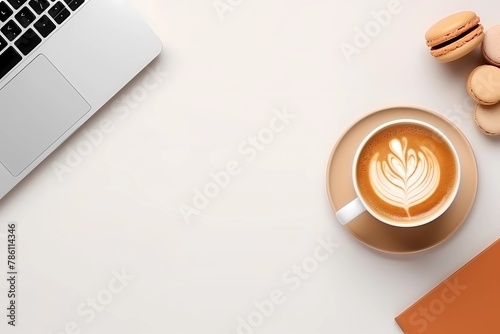 a laptop computer sitting next to a cup of coffee and macarons