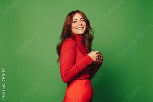 Happy woman with trendy style against green background © Jacob Lund