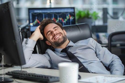 Happy trader looking at stock market graphs on computer screen in office desk photo