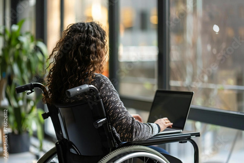 Disabled Worker in Wheelchair Using Laptop in Workplace