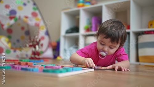little daughter plays with toys on the floor, develops fine motor skills. little daughter learning to lifestyle insert toy pictures into slots. happy family child dream concept
