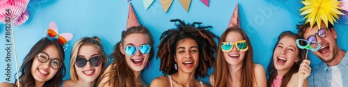 A group of friends posing for a photo with silly props at a birthday photo booth.