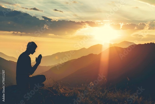 Silhouette of thankful man seeking god's praise and praising photo