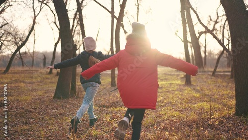 children run in the forest in autumn park. happy family kid dream concept. a group of children in jackets in the fall run in a park in the forest. nature freedom childhood concept