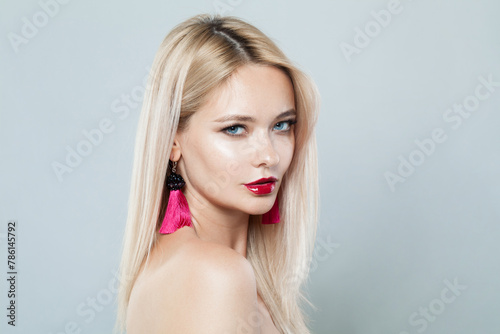 Attractive woman face close-up. Blonde model with fresh clear skin and healthy silky hair on white background