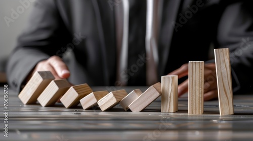 A man stands in the way of dominoes falling. Conflict management metaphor. photo