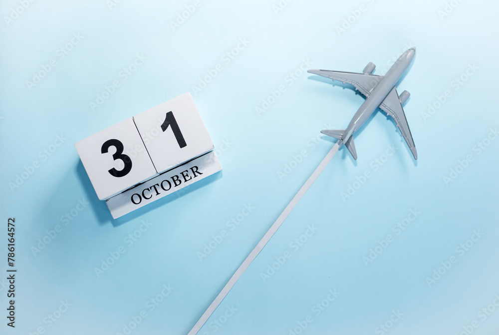 October calendar with number 31. Top view of a calendar with a flying passenger plane. Scheduler. Travel concept. Copy space. October calendar with number 31. Top view of a calendar with a flying passenger plane. Scheduler. Travel concept. Copy space.