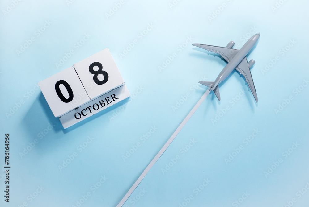 October calendar with number 8. Top view of a calendar with a flying passenger plane. Scheduler. Travel concept. Copy space. October calendar with number 8. Top view of a calendar with a flying passenger plane. Scheduler. Travel concept. Copy space.