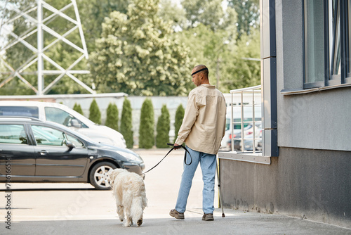 A disabled African American man with myasthenia gravis walks his Labrador dog on a leash, showcasing diversity and inclusion.