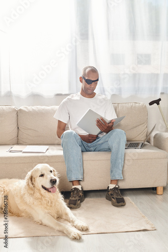 A disabled African American man with myasthenia gravis syndrome sitting on a couch next to a Labrador dog, embodying diversity and inclusion.