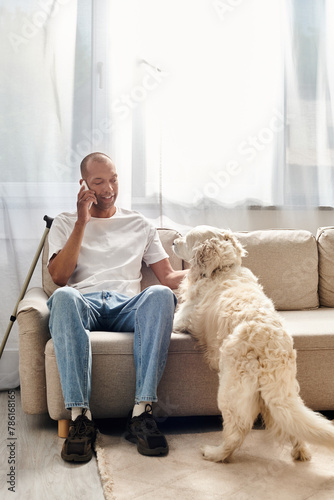 A man with myasthenia gravis converses on cell phone near his Labrador dog at home.