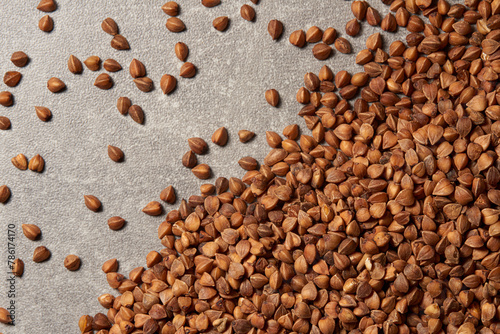 Close-up of a pile of buckwheat grains on the grey background.