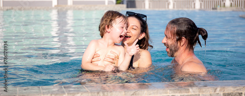 Caucasian family having enjoy and fun together with happiness in swimming pool, summer and holiday, mom, dad and son relax and playful, summertime and vacation, relation and bonding, family concept.