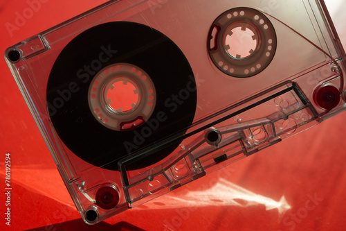 Silhouette of audio cassettes and glare on a red background.