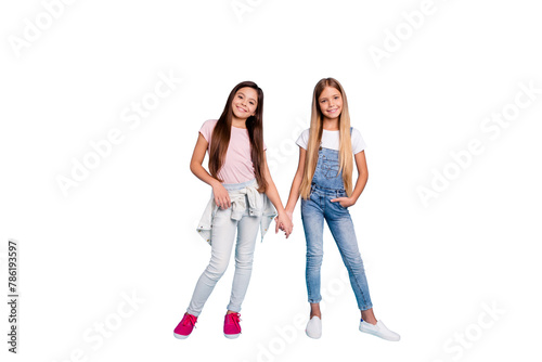 Full length body size view portrait of two people nice cheerful friendly kind straight-haired pre-teen girls holding hands spending free time trust support isolated on blue turquoise background