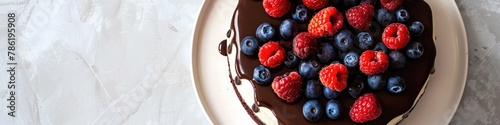 A birthday cake topped with chocolate  and fresh berries, ready to be served.