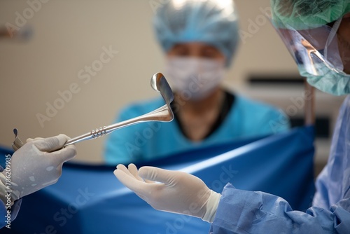 Hand of Team surgery doctor in Operating Room hold operating stretcher give to Surgeons During Operation. surgeons assistance in green gown coat give steel operating stretcher to doctor