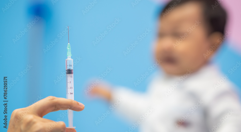 pediatrician Hand hold vaccine liquid injection in syringe for injecting child baby infant. small syringe needle for infant prevention flu by vaccination immunity in Pediatrics hospital clinic. pediatrician Hand hold vaccine liquid injection in syringe for injecting child baby infant. small syringe needle for infant prevention flu by vaccination immunity in Pediatrics hospital clinic.