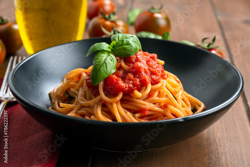 Piatto di deliziosi spaghetti con pomodoro, basilico e olio extravergine di oliva, dieta mediterranea, pasta italiana 