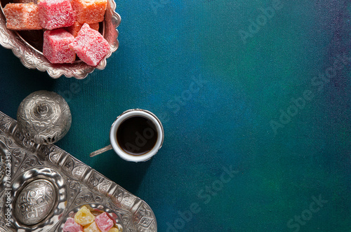 Traditional Turkish coffee and Turkish delight on a painted dark blue-green wooden background