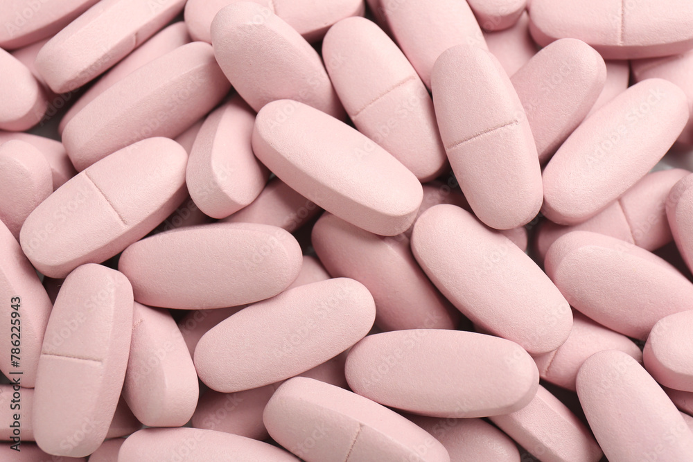 Pink vitamin capsules as background, top view Pink vitamin capsules as background, top view