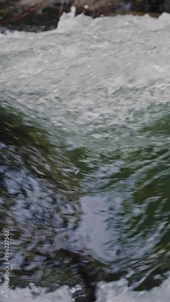 Extreme close-up. Clear stream running through stone boulders abundant river flowing on stone bottom in super slow motion. Wild mountain river water splashing in summer day. Beautiful pure water. Extreme close-up. Clear stream running through stone boulders abundant river flowing on stone bottom in super slow motion. Wild mountain river water splashing in summer day. Beautiful pure water.