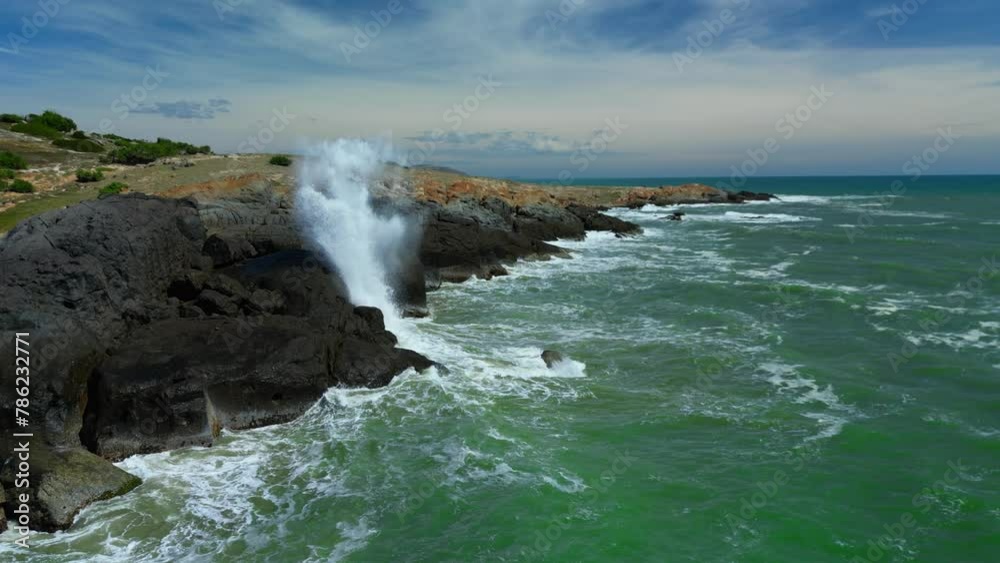 Aerial top view of waves crashing on rocks in a blue ocean. Sea waves on a beautiful beach aerial view a 4k. Bird's eye view of ocean waves crashing against an empty stone cliff from the summit. Aerial top view of waves crashing on rocks in a blue ocean. Sea waves on a beautiful beach aerial view a 4k. Bird's eye view of ocean waves crashing against an empty stone cliff from the summit.