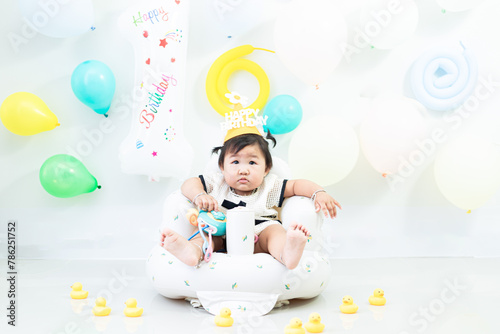 A young girl celebrates her 1st birthday. A young Asian girl celebrates her first birthday.