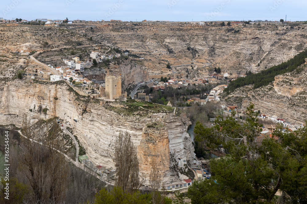 Panoramic view of the town of Alcalá del júcar from Casas del Cerro. Its popular cave houses, carved into the mountain, the castle and Church of San Andrés in the gorge of the júcar rive, Albacete.