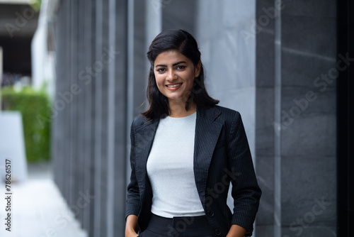 Indian Asian business woman - Portrait Smiling Young Businesswoman in black suit at outside modern office building. Positive human emotions