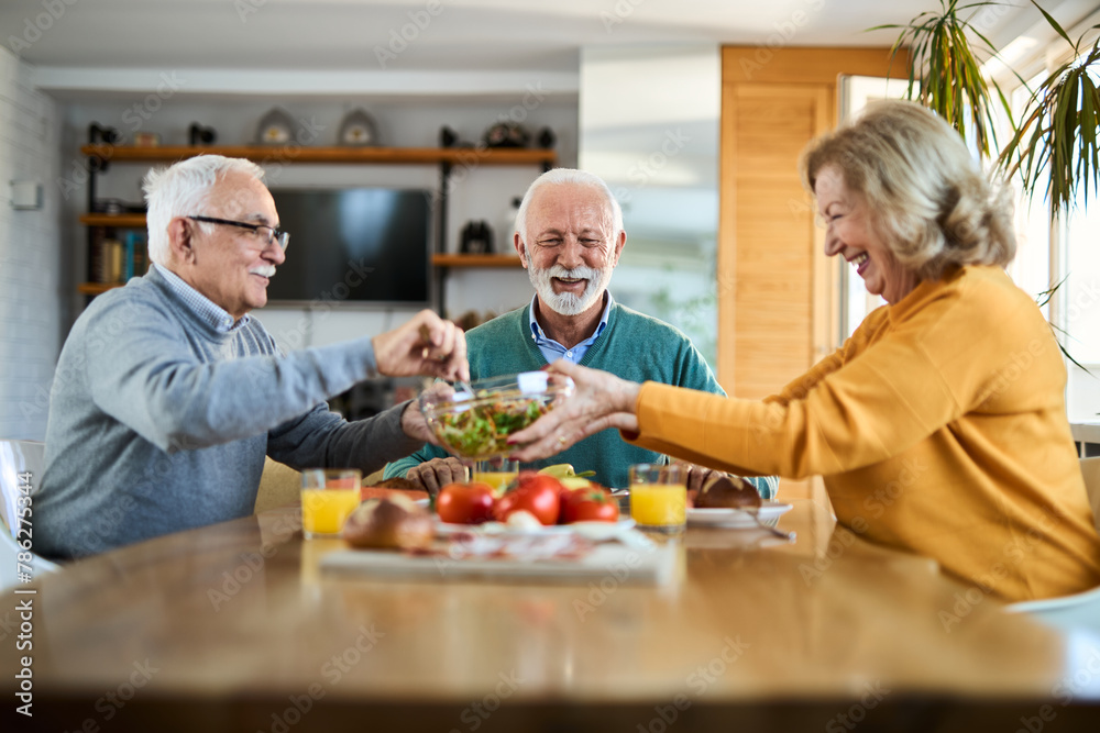 Group of happy senior friends talking while having a meal at dining table.
Group of happy senior friends talking while having a meal at dining table.