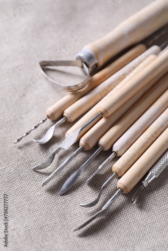 Set of different clay crafting tools on grey fabric, closeup